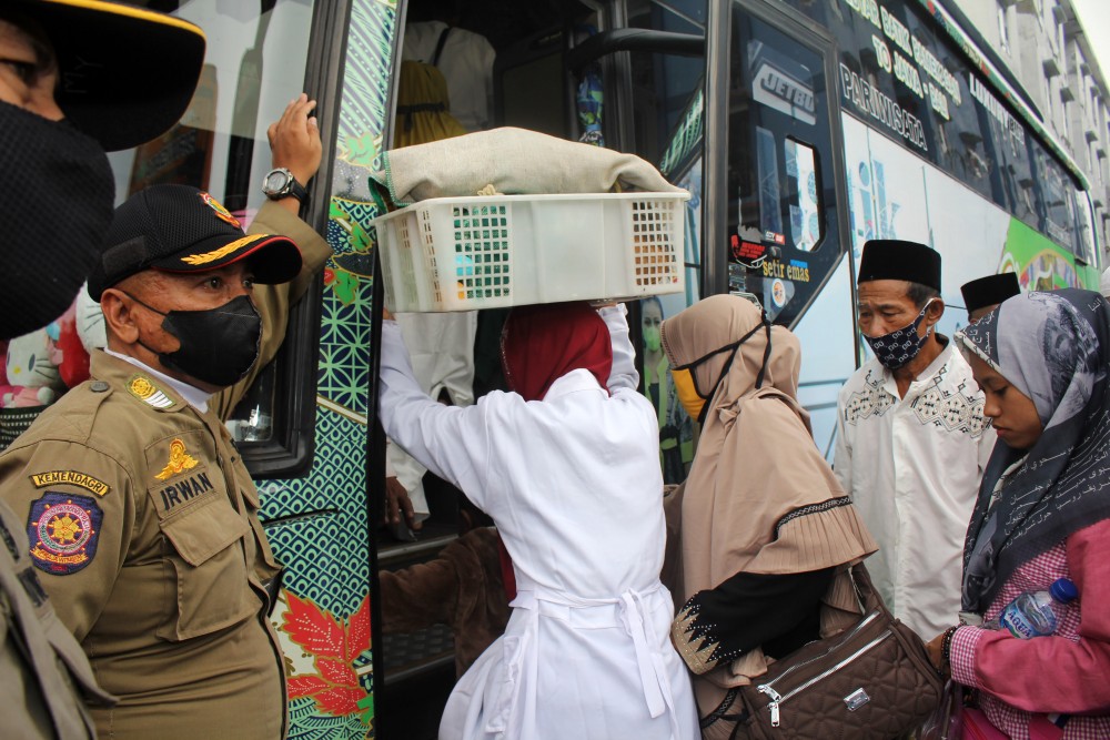 Petugas mengawasi sejumlah pengungsi yang merupakan mantan pengikut aliran syiah dari Sampang saat antre menaiki bus di Rusunawa Jemundo, Sidoarjo. ANTARA/Patrik Cahyo